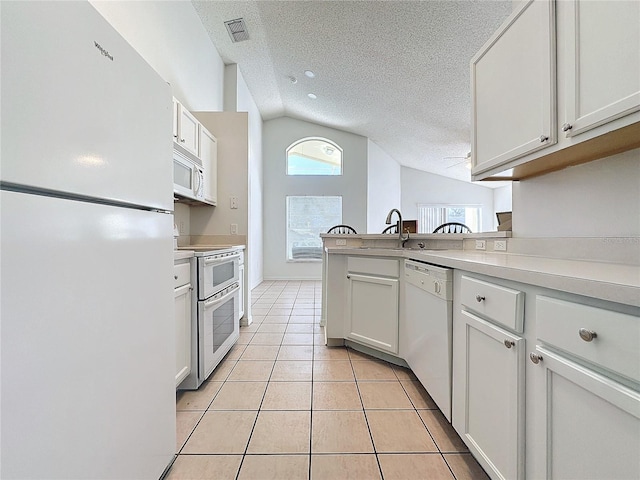 kitchen featuring white cabinets, white appliances, a textured ceiling, and vaulted ceiling