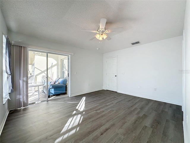 unfurnished room featuring a textured ceiling, dark hardwood / wood-style floors, and ceiling fan