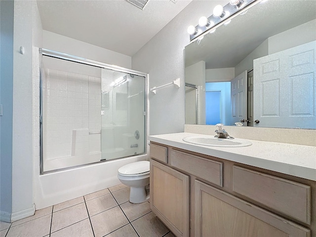 full bathroom with tile patterned flooring, bath / shower combo with glass door, a textured ceiling, toilet, and vanity