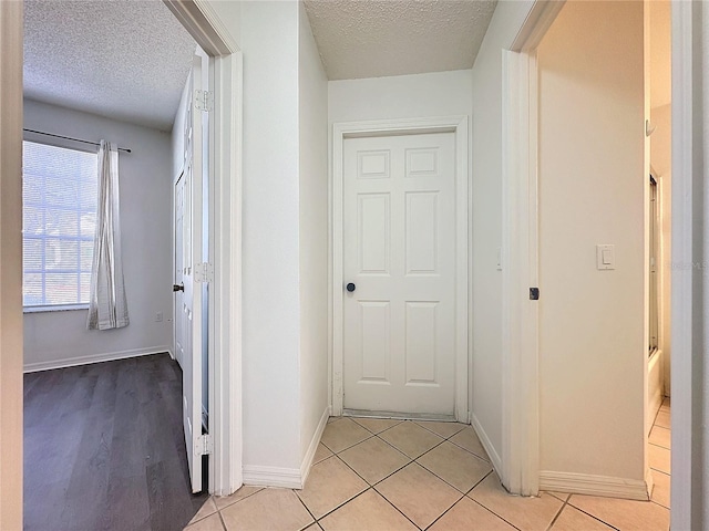 hallway with light tile patterned flooring and a textured ceiling