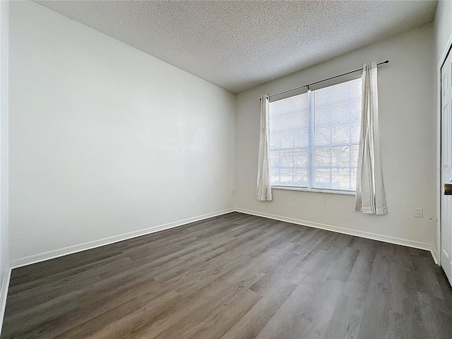 unfurnished room with wood-type flooring and a textured ceiling