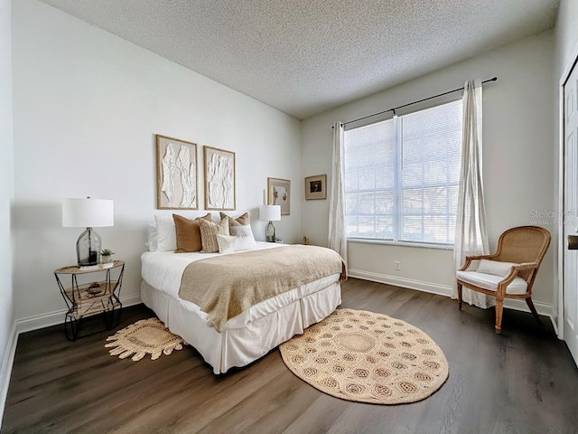 bedroom with a textured ceiling and dark wood-type flooring