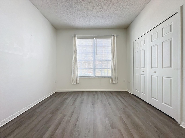 unfurnished bedroom with a closet, wood-type flooring, and a textured ceiling