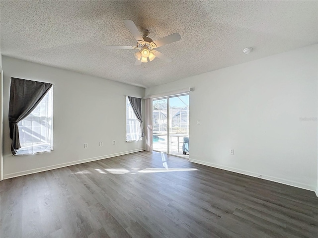 spare room featuring a textured ceiling, ceiling fan, and dark wood-type flooring