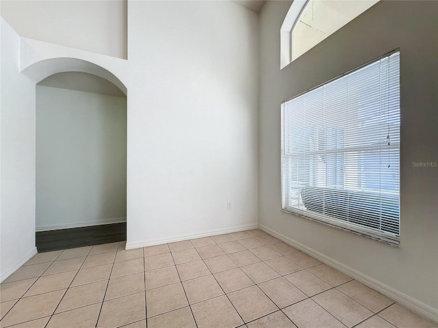 spare room with light tile patterned floors and plenty of natural light