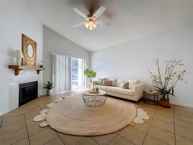 living room with a tile fireplace, ceiling fan, light tile patterned floors, and high vaulted ceiling