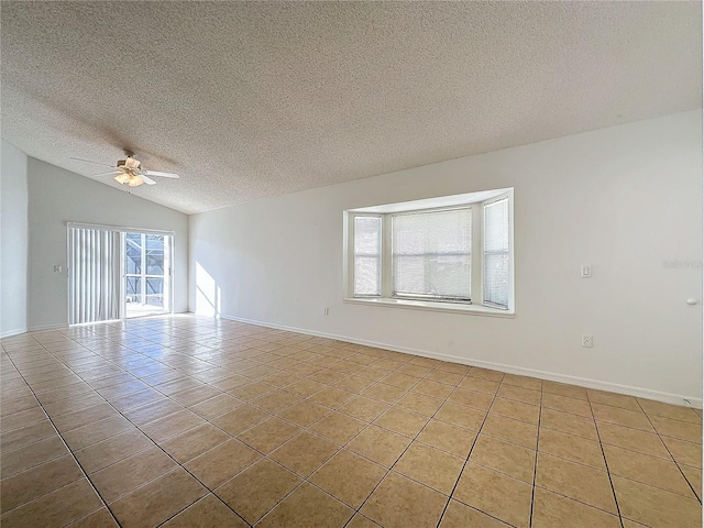 empty room with a textured ceiling, ceiling fan, light tile patterned floors, and lofted ceiling