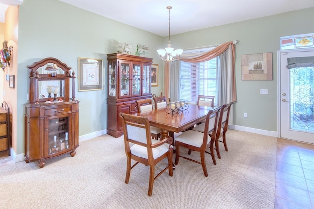 carpeted dining area featuring a notable chandelier