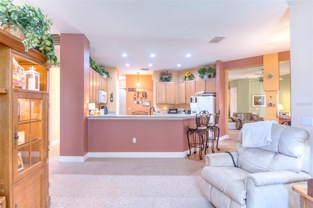 carpeted living room featuring ceiling fan and sink