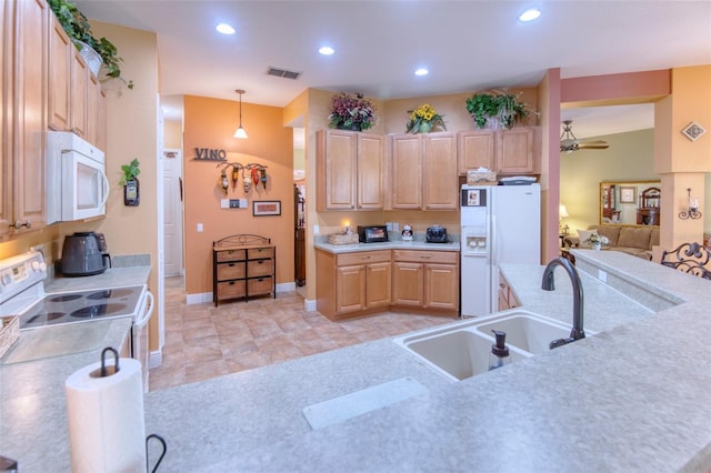 kitchen featuring light brown cabinetry, hanging light fixtures, white appliances, and sink