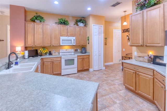 kitchen with pendant lighting, white appliances, sink, and light brown cabinetry