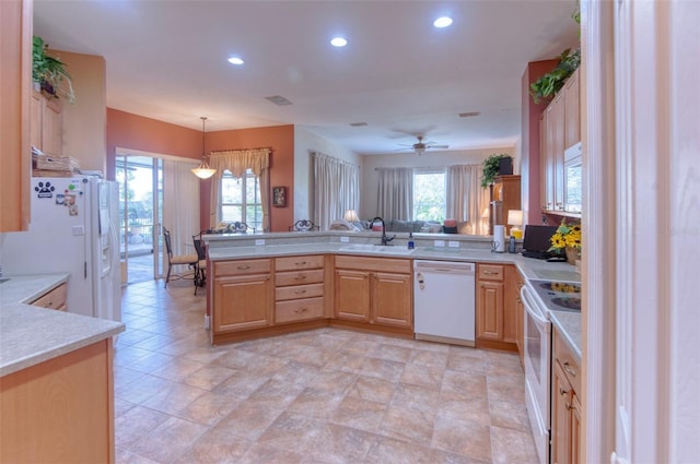 kitchen with pendant lighting, white appliances, sink, light brown cabinetry, and kitchen peninsula