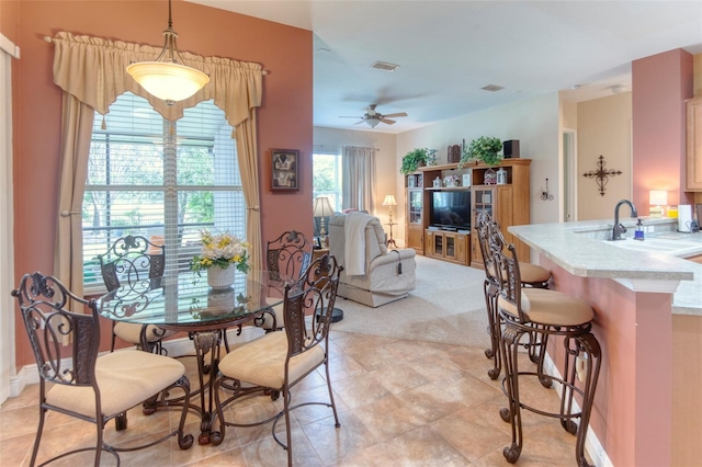 dining area with ceiling fan and sink