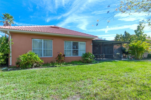 back of property with a lawn and a sunroom