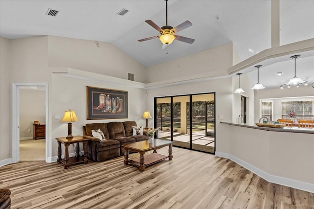 living room with ceiling fan, high vaulted ceiling, and light wood-type flooring