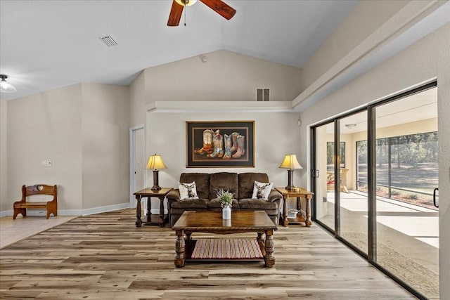 living room with ceiling fan, vaulted ceiling, and light wood-type flooring