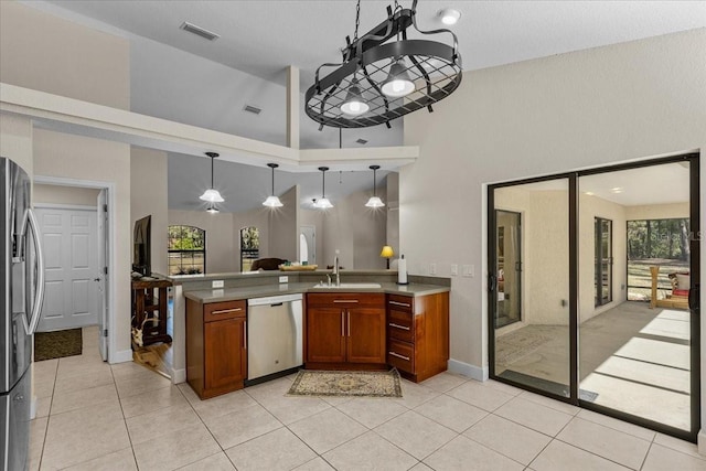 kitchen with sink, hanging light fixtures, stainless steel appliances, high vaulted ceiling, and light tile patterned floors