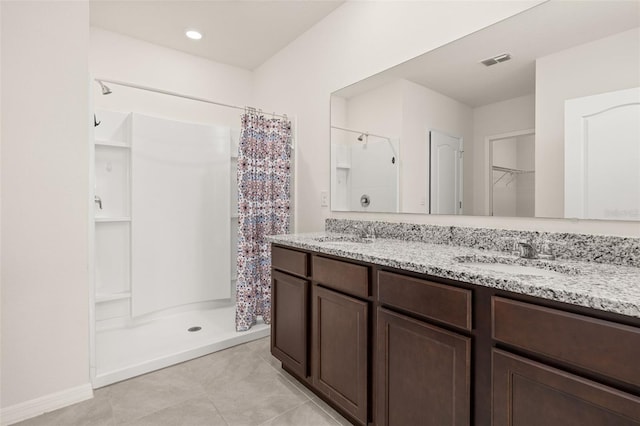 bathroom featuring vanity, tile patterned floors, and walk in shower