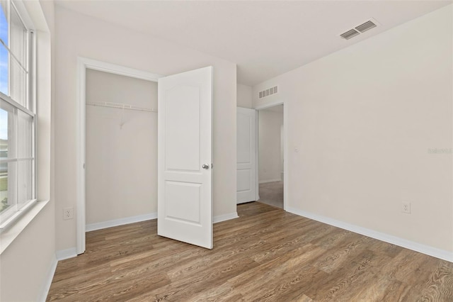 unfurnished bedroom with a closet and hardwood / wood-style floors