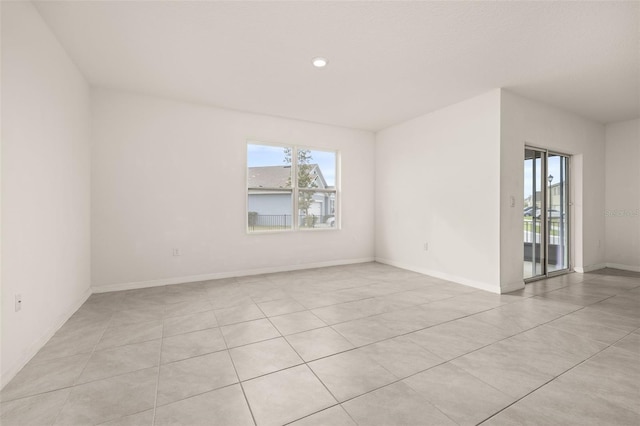 spare room featuring light tile patterned floors and a wealth of natural light