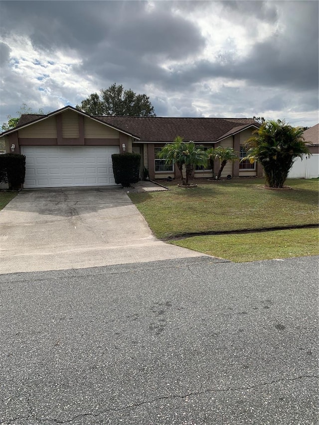 single story home featuring a garage and a front lawn