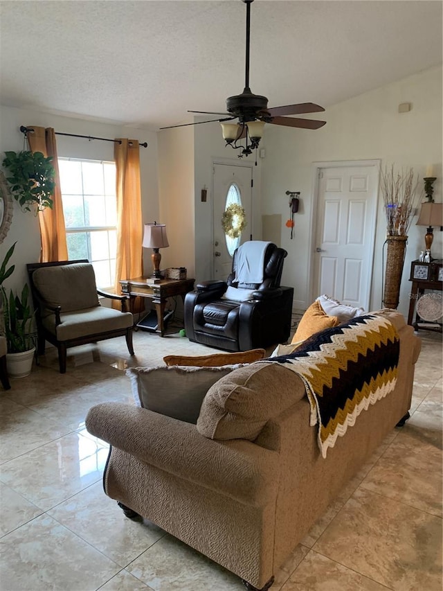 living room with a textured ceiling and ceiling fan