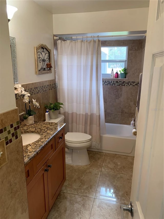 full bathroom featuring shower / tub combo, vanity, toilet, and tile walls