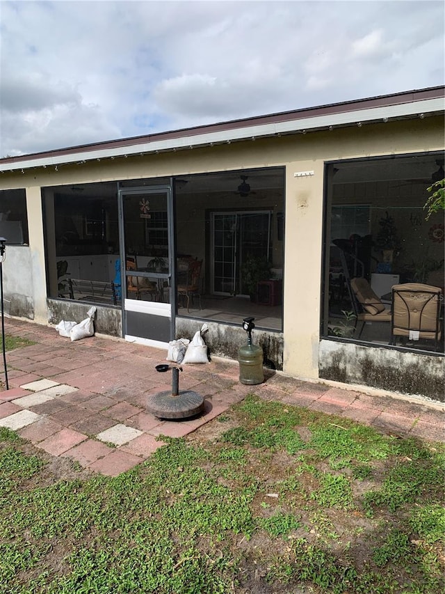 rear view of house featuring a patio area and a sunroom