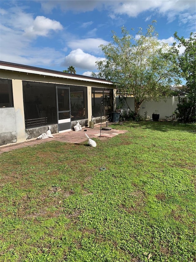 view of yard featuring a sunroom and a patio area