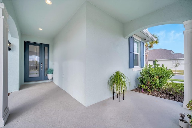 entrance to property featuring a patio area and stucco siding