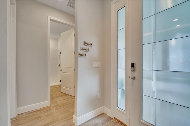 entryway featuring light wood-type flooring, visible vents, and baseboards