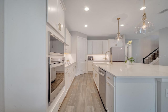 kitchen with stainless steel appliances, visible vents, white cabinets, light countertops, and light wood-type flooring