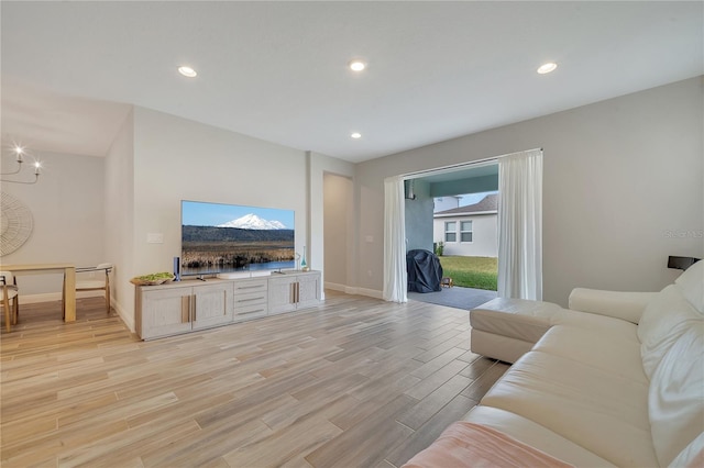 living room with baseboards, light wood-style flooring, and recessed lighting