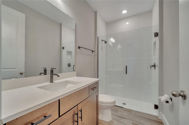 full bath featuring toilet, a shower stall, wood tiled floor, and vanity