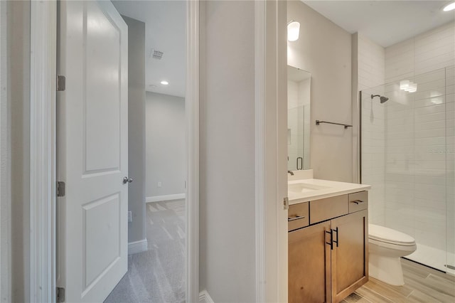 bathroom with visible vents, toilet, a shower stall, and vanity