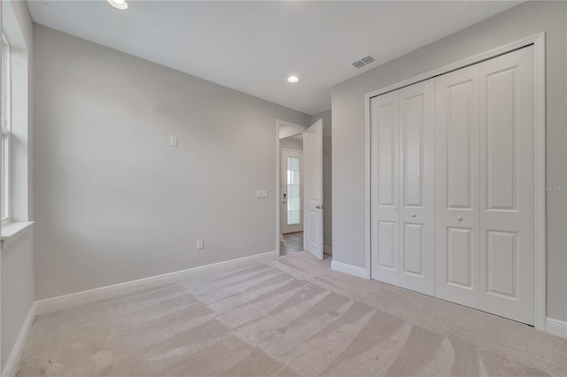 unfurnished bedroom with recessed lighting, carpet floors, visible vents, baseboards, and a closet