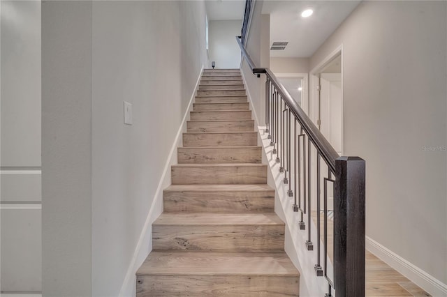 stairs featuring visible vents, baseboards, and wood finished floors