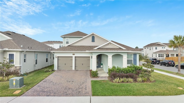 view of front of property with an attached garage, covered porch, decorative driveway, stucco siding, and a front lawn