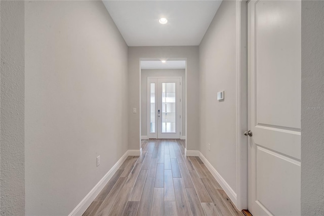 doorway featuring light wood-type flooring and baseboards