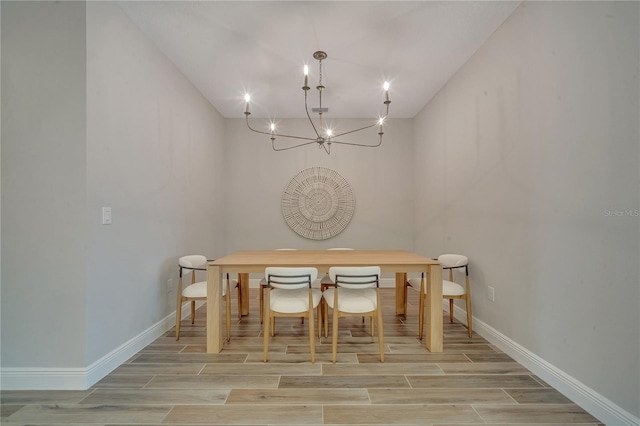 unfurnished dining area featuring a chandelier, baseboards, and wood tiled floor