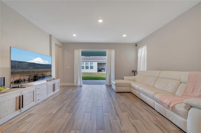 living room featuring light wood-style flooring, baseboards, and recessed lighting