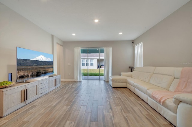 living area featuring light wood-style floors, baseboards, and recessed lighting