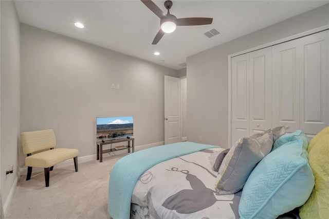 bedroom with ceiling fan, light carpet, visible vents, baseboards, and a closet