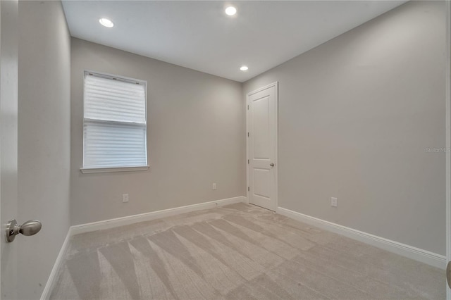 empty room with recessed lighting, light carpet, and baseboards