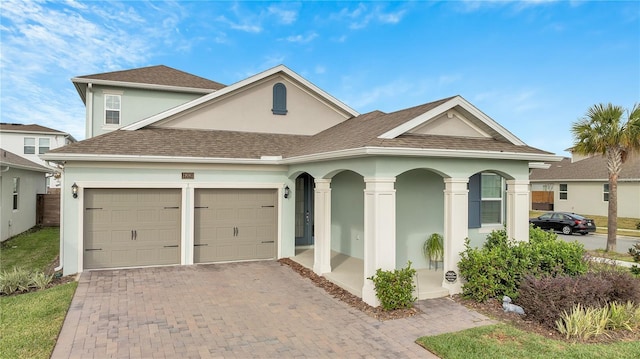 19041 Blueleaf St, Orlando, FL 32827 - view of front facade featuring stucco siding, a garage, decorative driveway, and a shingled roof