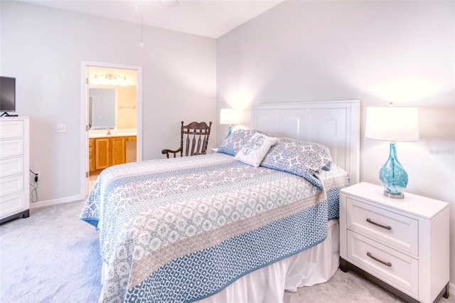 bedroom featuring connected bathroom and light colored carpet