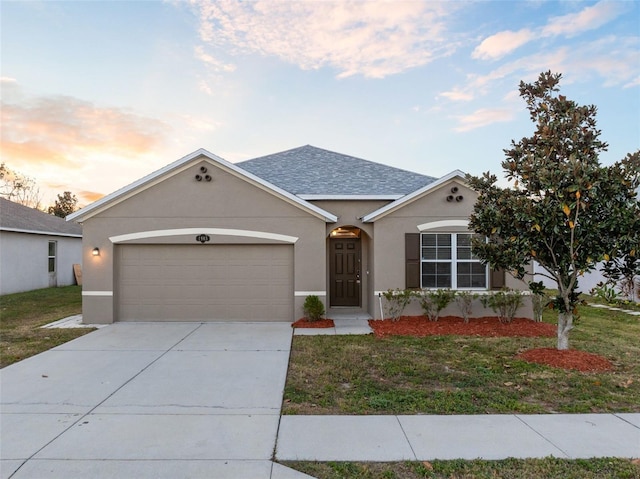 single story home featuring a lawn and a garage