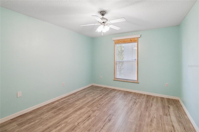 empty room with ceiling fan, light hardwood / wood-style floors, and a textured ceiling