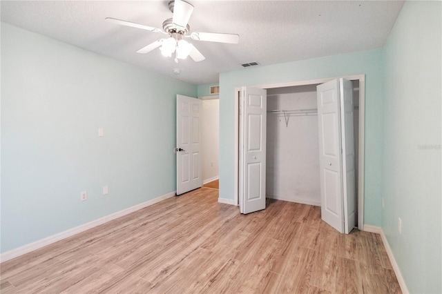 unfurnished bedroom featuring light wood-type flooring, a textured ceiling, ceiling fan, and a closet