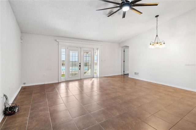 tiled spare room with french doors, lofted ceiling, ceiling fan with notable chandelier, and a textured ceiling